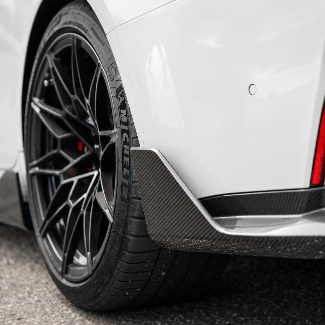 AlpineX Dynamics MP Style Carbon Fiber Rear Spats Winglets installed on a BMW G80 M3 featuring a glossy carbon fiber finish and an aggressive rear-end aerodynamic upgrade.