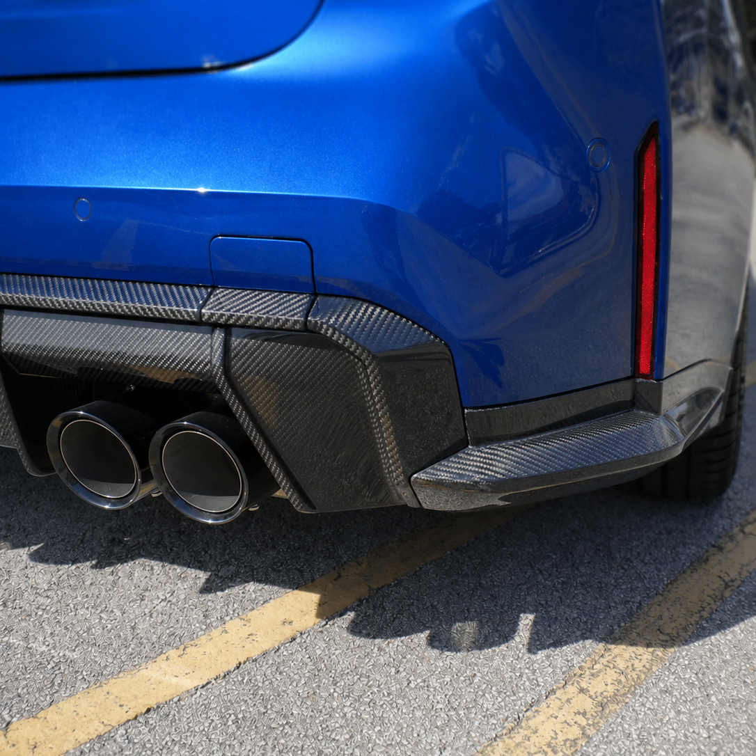 AlpineX Dynamics OEM Style Carbon Fiber Rear Spats Winglets installed on a BMW G80 M3 featuring a glossy carbon fiber finish and a subtle aerodynamic upgrade for the rear bumper.